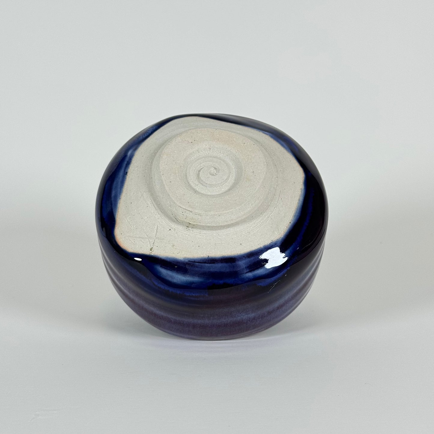 Bottom view of handmade Japanese amethyst haze matcha bowl showing unglazed foot