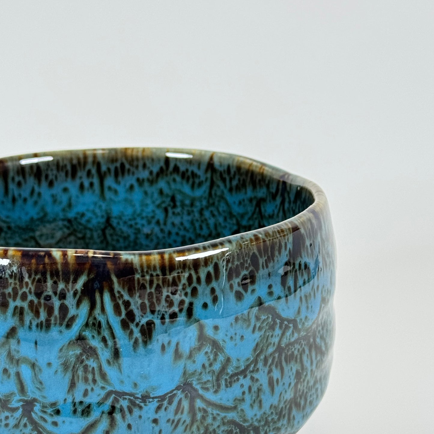 Close-up of blue glazed Japanese chawan with textured surface and layered glaze pattern