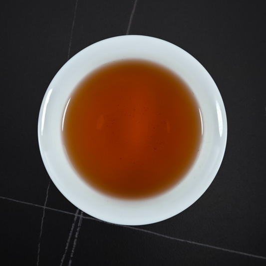 amber liquor of da hong pao oolong tea in white cup