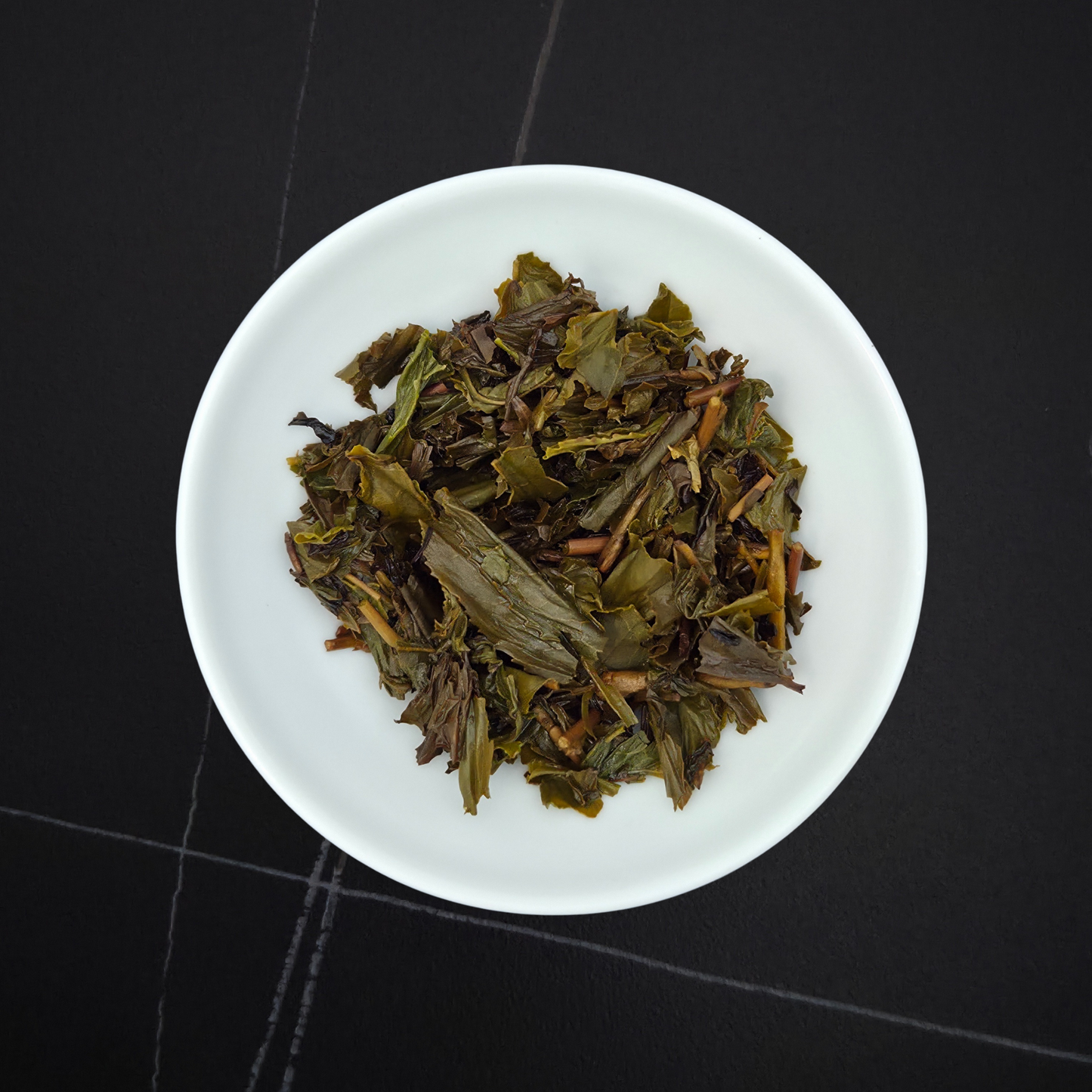wet leaves of lightly roasted hojicha showing green and brown tones
