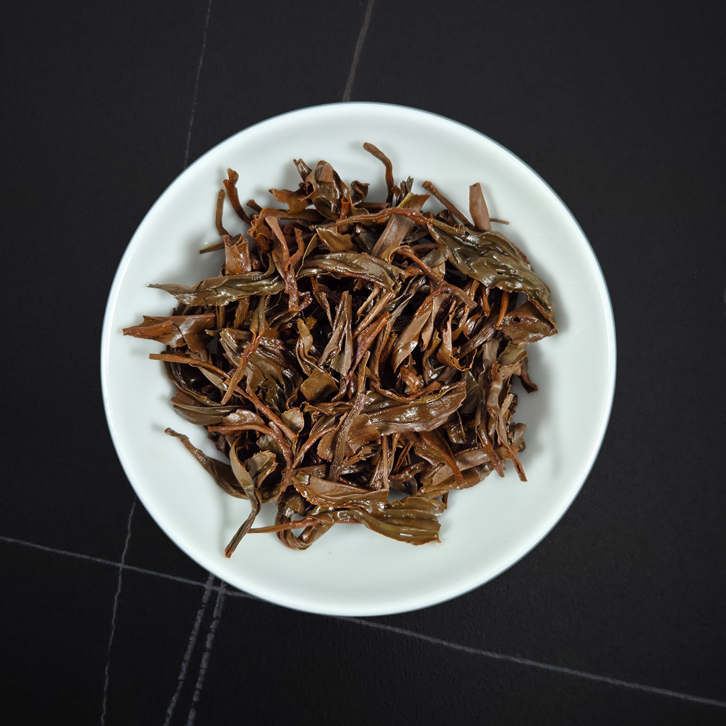 Close up of Zheng Shan Xiao Zhong tea leaves showing twisted small leaf structure Wuyi black tea