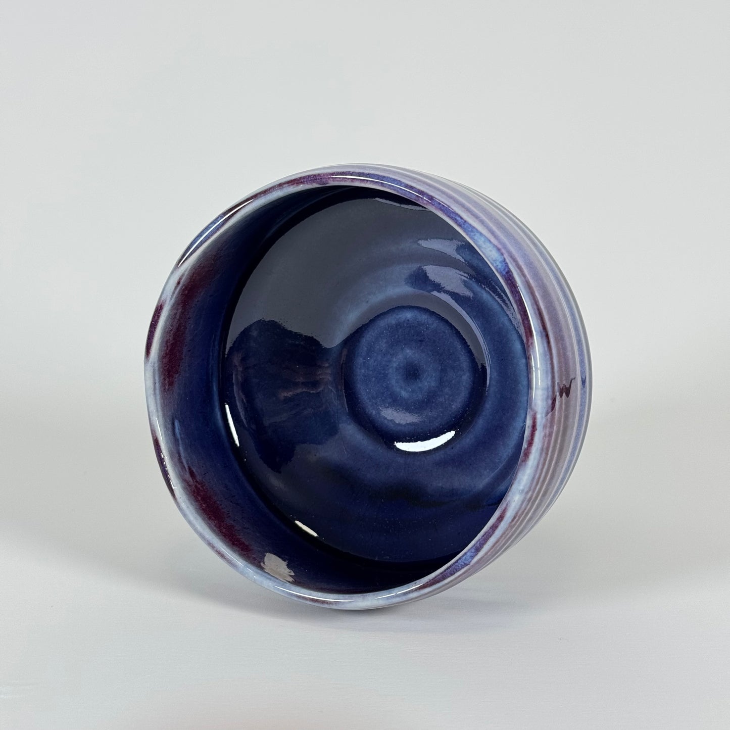 Interior view of handmade Japanese amethyst haze chawan with deep blue glaze