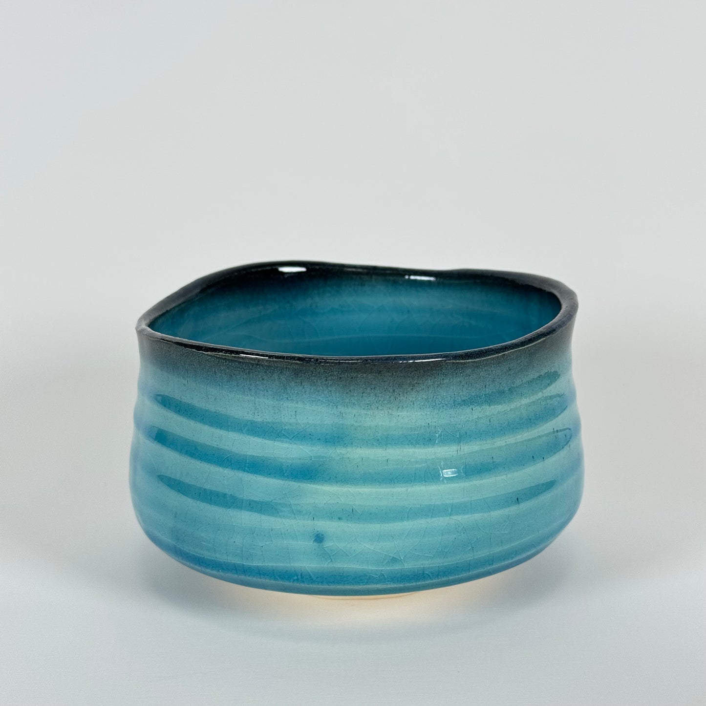 Handmade Japanese matcha bowl with ocean blue gradient glaze and charcoal rim ceramic chawan