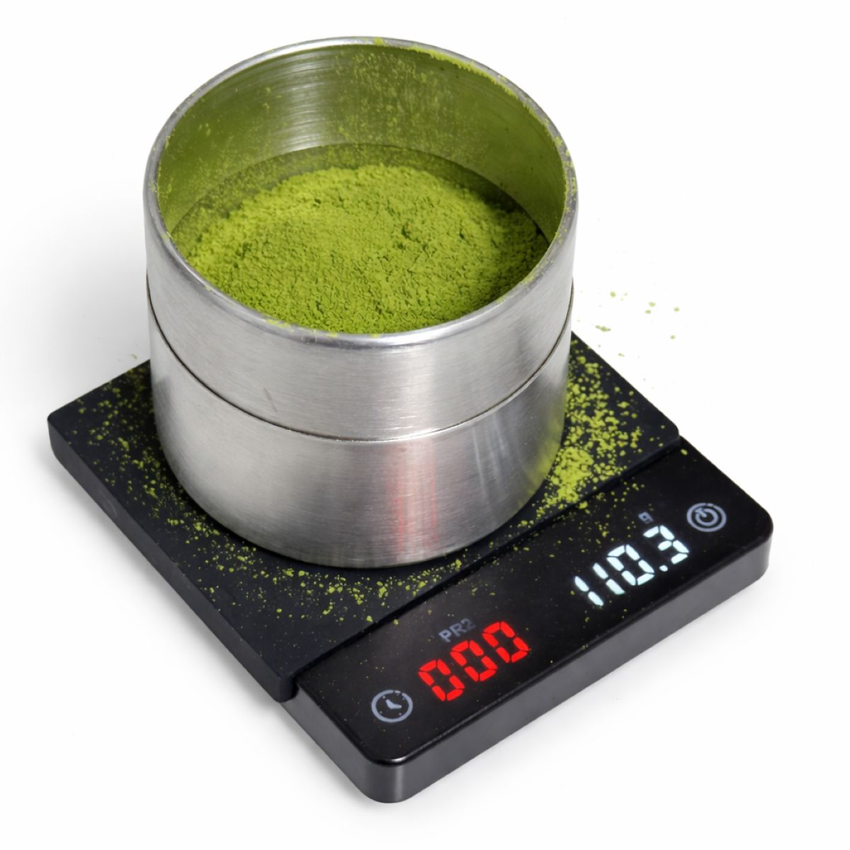 matcha powder in metal tin with green tea powder inside on a digital scale