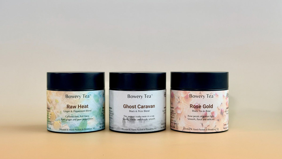 Three Bowery Tea cosmetic jars lined up on a light beige surface against a neutral light gray background. The jars are labeled Raw Heat, Ghost Caravan, and Rose Gold.