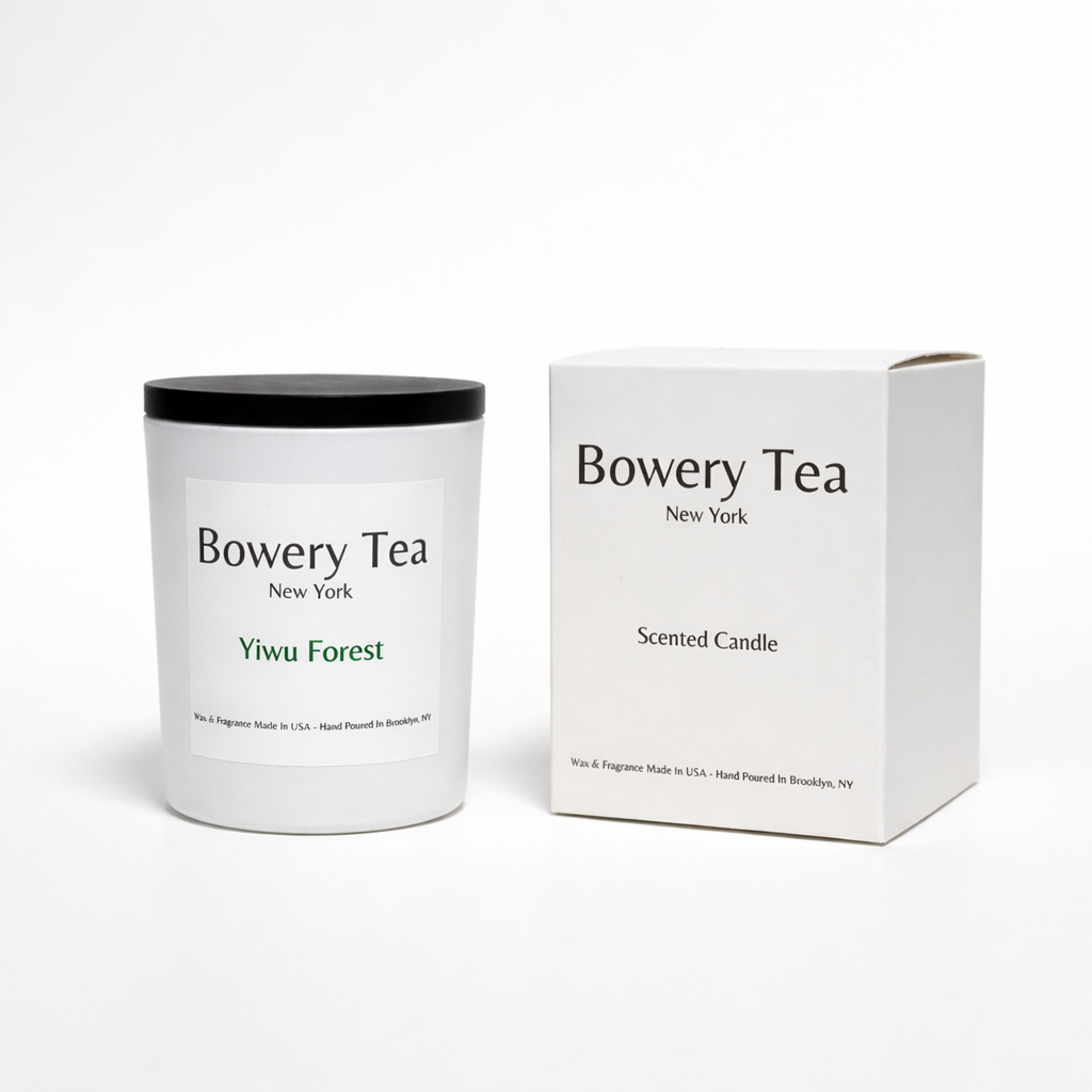 Bowery Tea Yiwu Forest scented candle in white glass container with black lid and packaging box