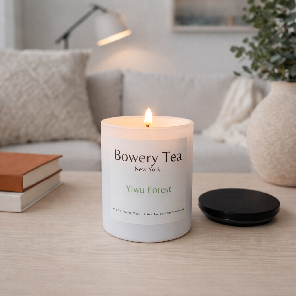 Bowery Tea candle on a table with a cozy living room background