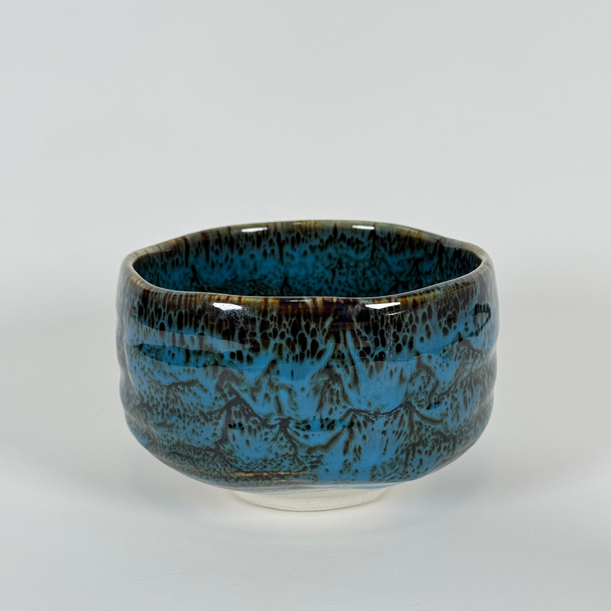 Handmade Japanese matcha bowl with ocean blue and earthy brown glaze inspired by waves under a night sky