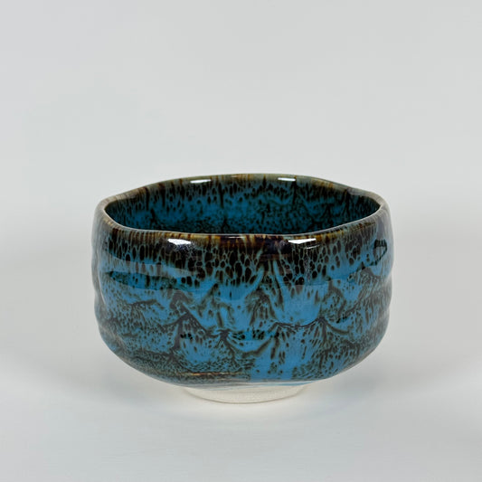 Handmade Japanese matcha bowl with ocean blue and earthy brown glaze inspired by waves under a night sky