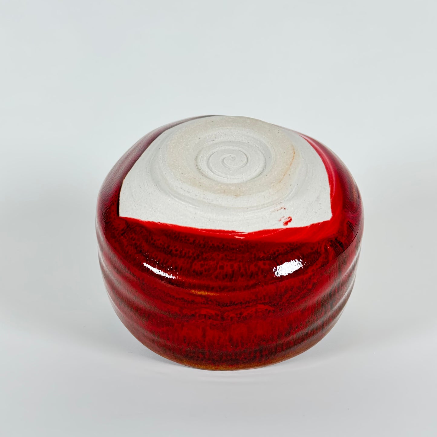 Handmade Japanese crimson glazed matcha bowl showing unglazed foot and base detail
