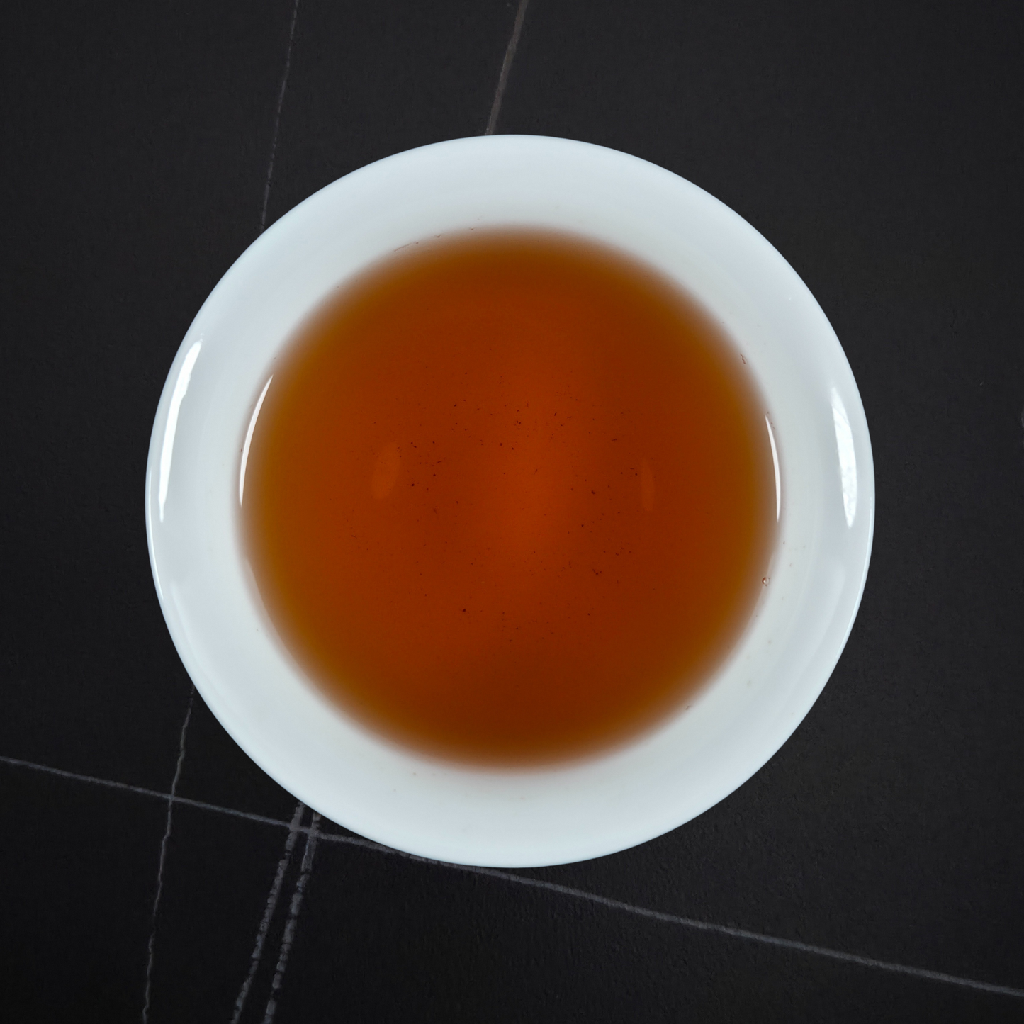 amber liquor of da hong pao oolong tea in white cup