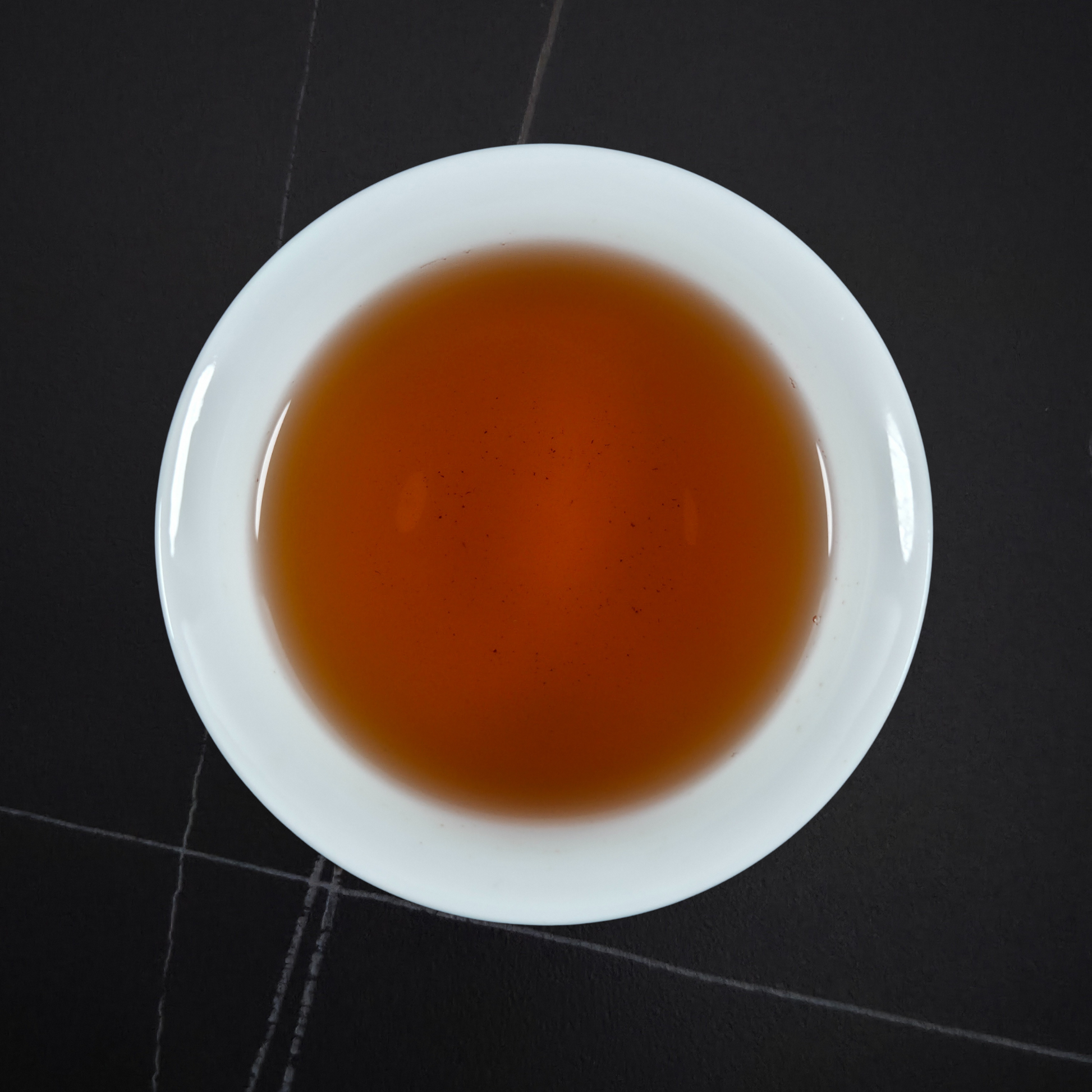 amber liquor of da hong pao oolong tea in white cup