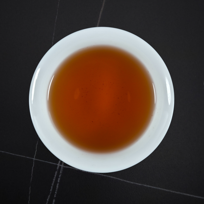 amber liquor of da hong pao oolong tea in white cup