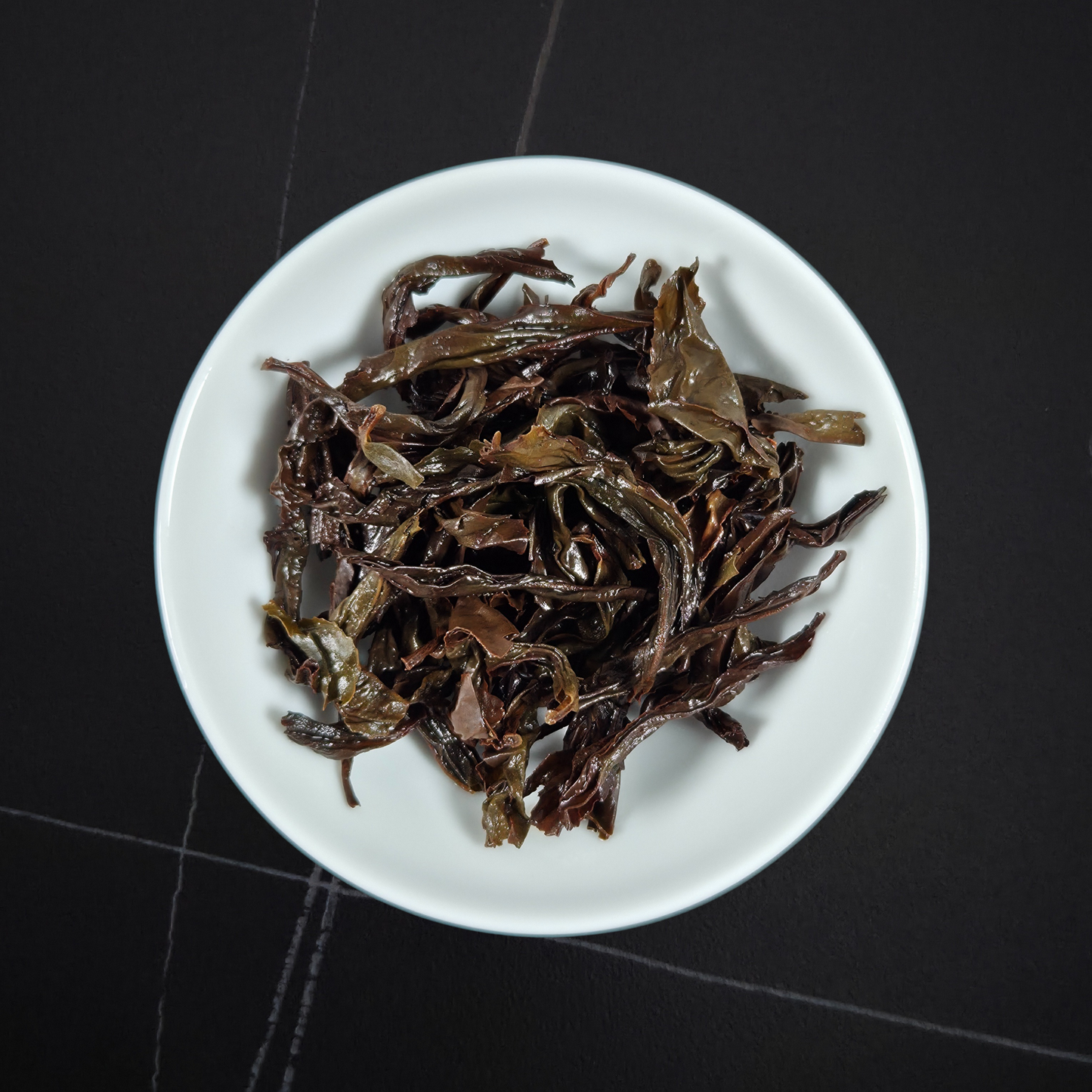 wet leaves of da hong pao showing twisted dark strips