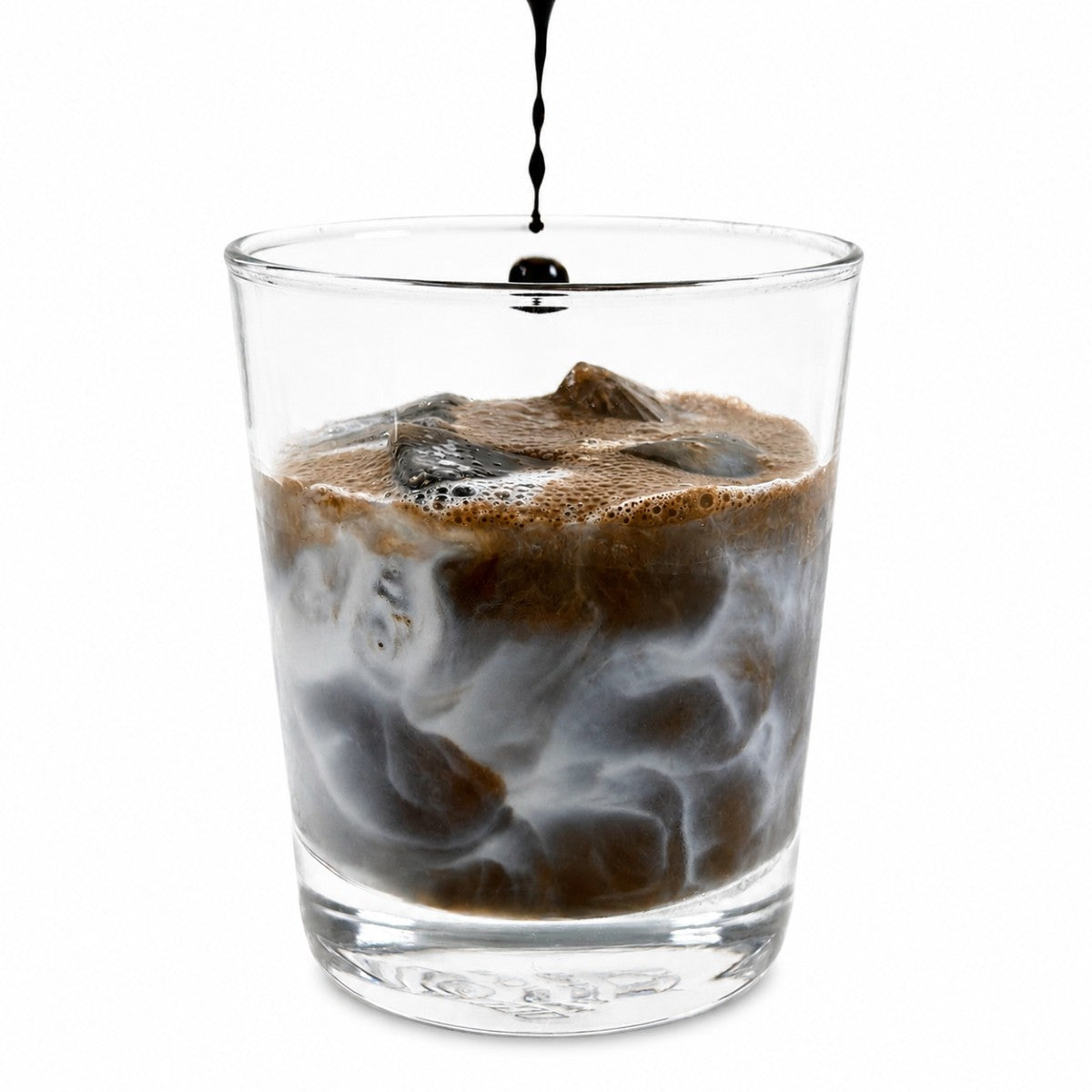 Glass of iced coffee with a stream of liquid being poured on a white background
