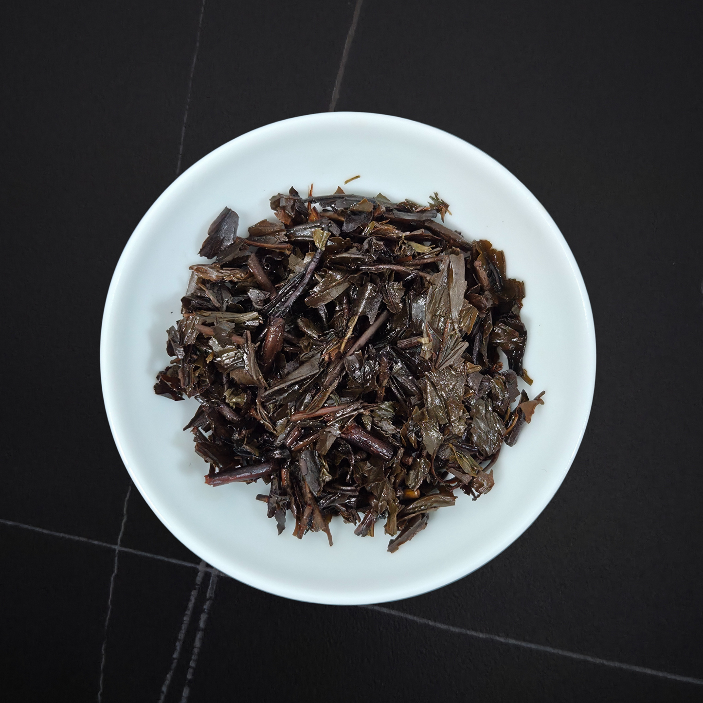 wet leaves of dark roasted hojicha showing stems and leaves
