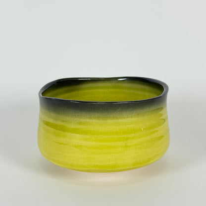 Handmade Japanese matcha bowl with bright golden yellow glaze and charcoal rim ceramic chawan