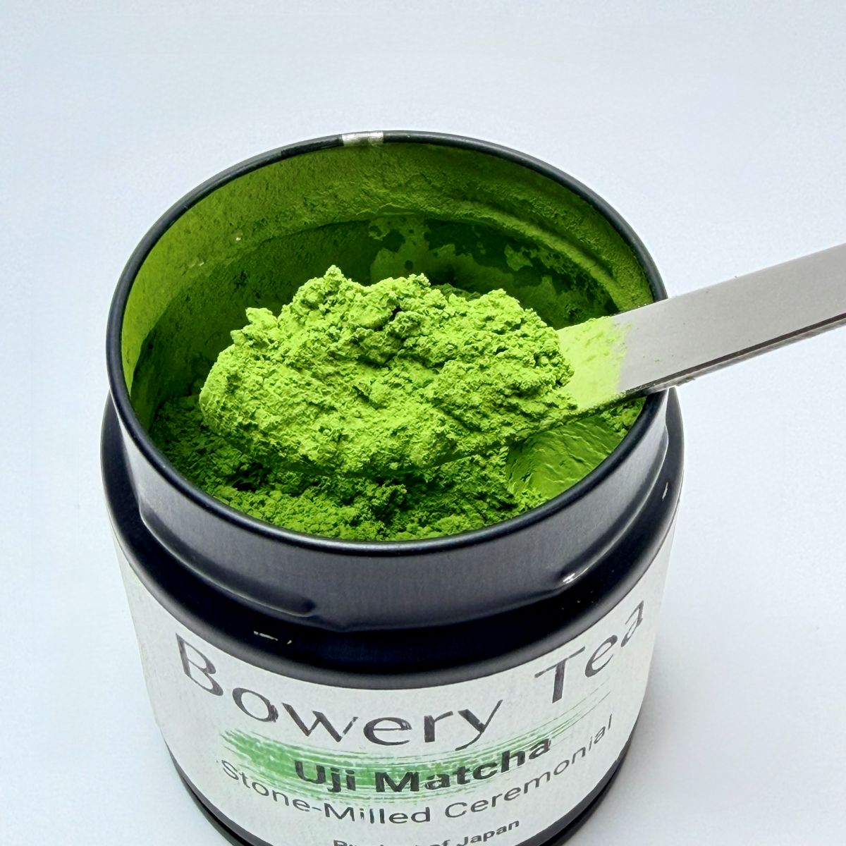 Jar of Uji Matcha green tea powder with a spoon inside, branded 'Bowery Tea'.