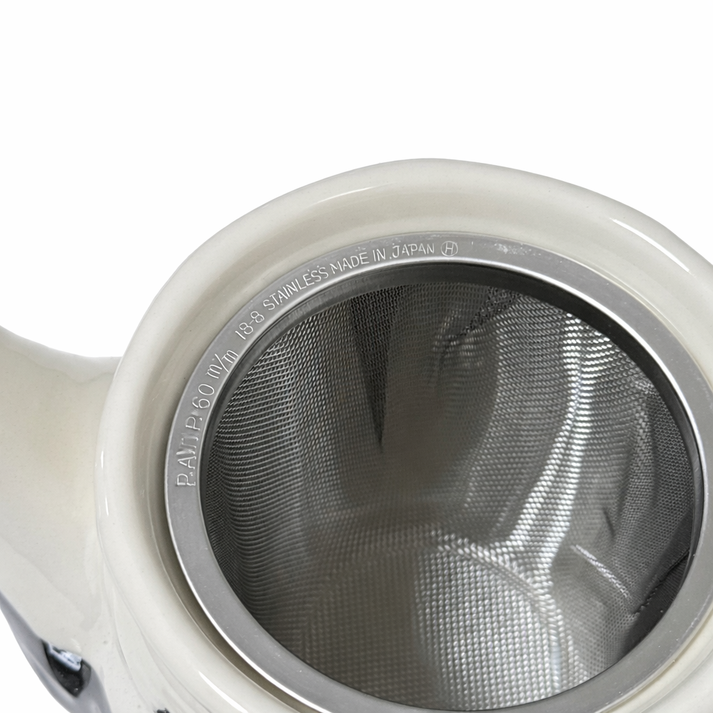 Close up of stainless steel tea infuser inside Japanese teapot for loose leaf brewing