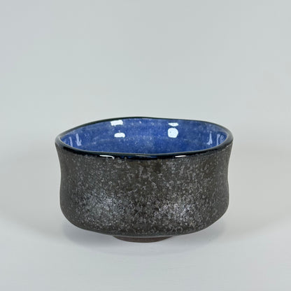 Handmade Japanese matcha bowl with charcoal textured exterior and cobalt blue interior glaze