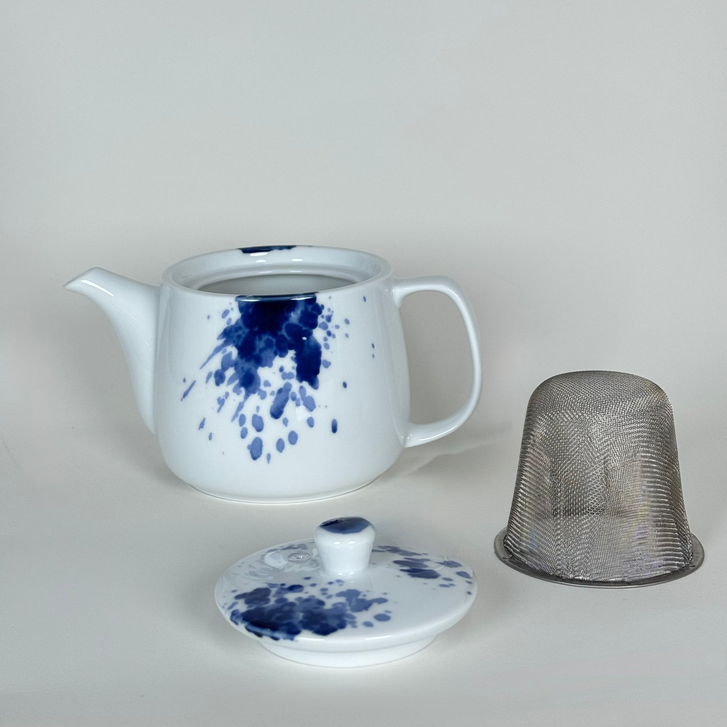 Gosu Mino ware teapot with lid removed and stainless steel strainer next to it miyama japan