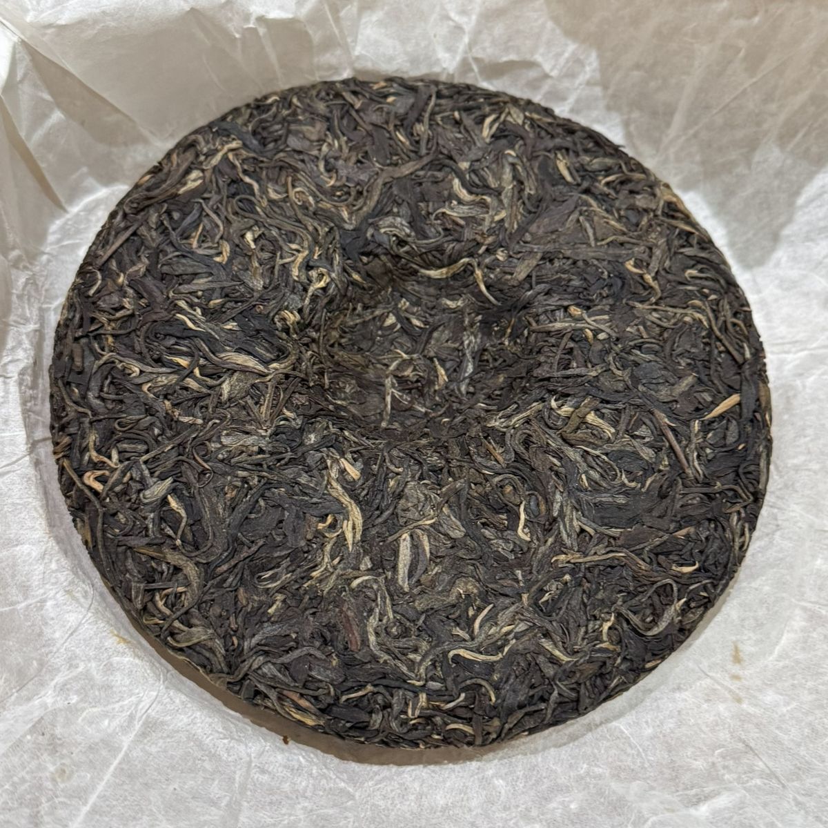 Compressed pu-er tea cake showing aged, fermented tea leaves