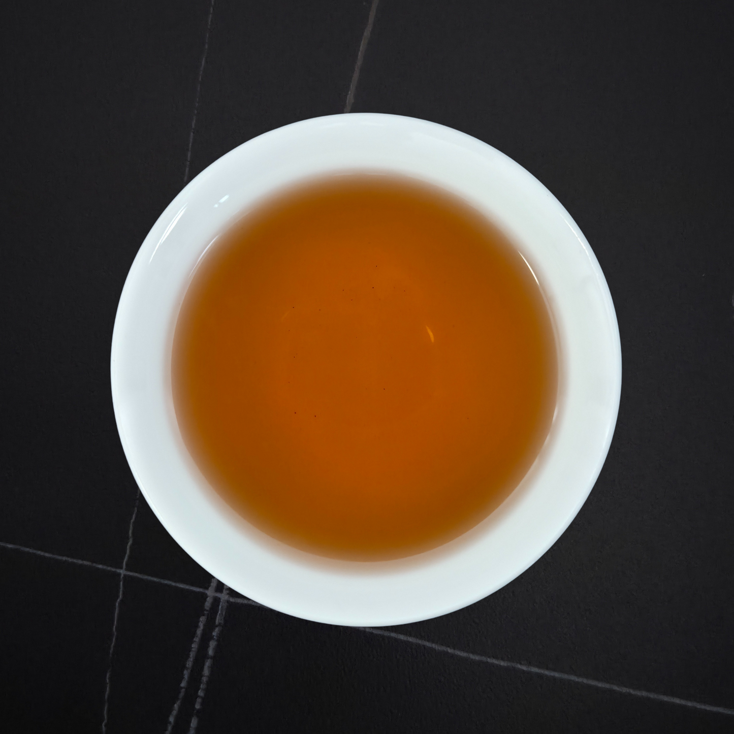 amber liquor of taiwan red oolong tea in white cup