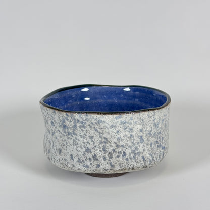 Handmade Japanese stoneware matcha bowl with textured gray exterior and deep cobalt blue interior glaze