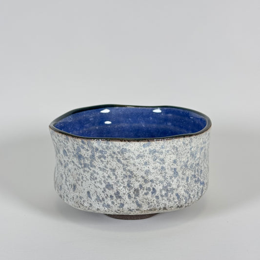 Handmade Japanese stoneware matcha bowl with textured gray exterior and deep cobalt blue interior glaze