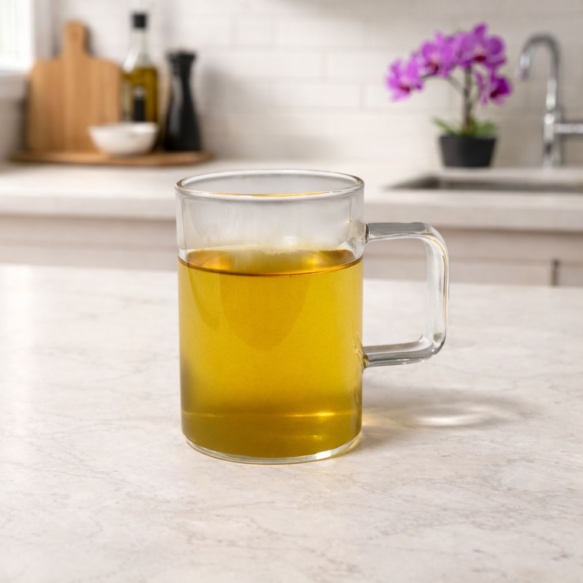 Clear glass mug filled with brewed tea on a kitchen counter, illustrating basic tea brewing