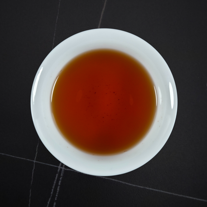 Cup of Zheng Shan Xiao Zhong black tea with amber liquor smooth sweet and lightly roasted