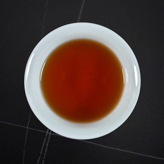 Cup of Zheng Shan Xiao Zhong black tea with amber liquor smooth sweet and lightly roasted