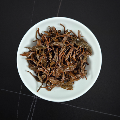 Close up of Zheng Shan Xiao Zhong tea leaves showing twisted small leaf structure Wuyi black tea